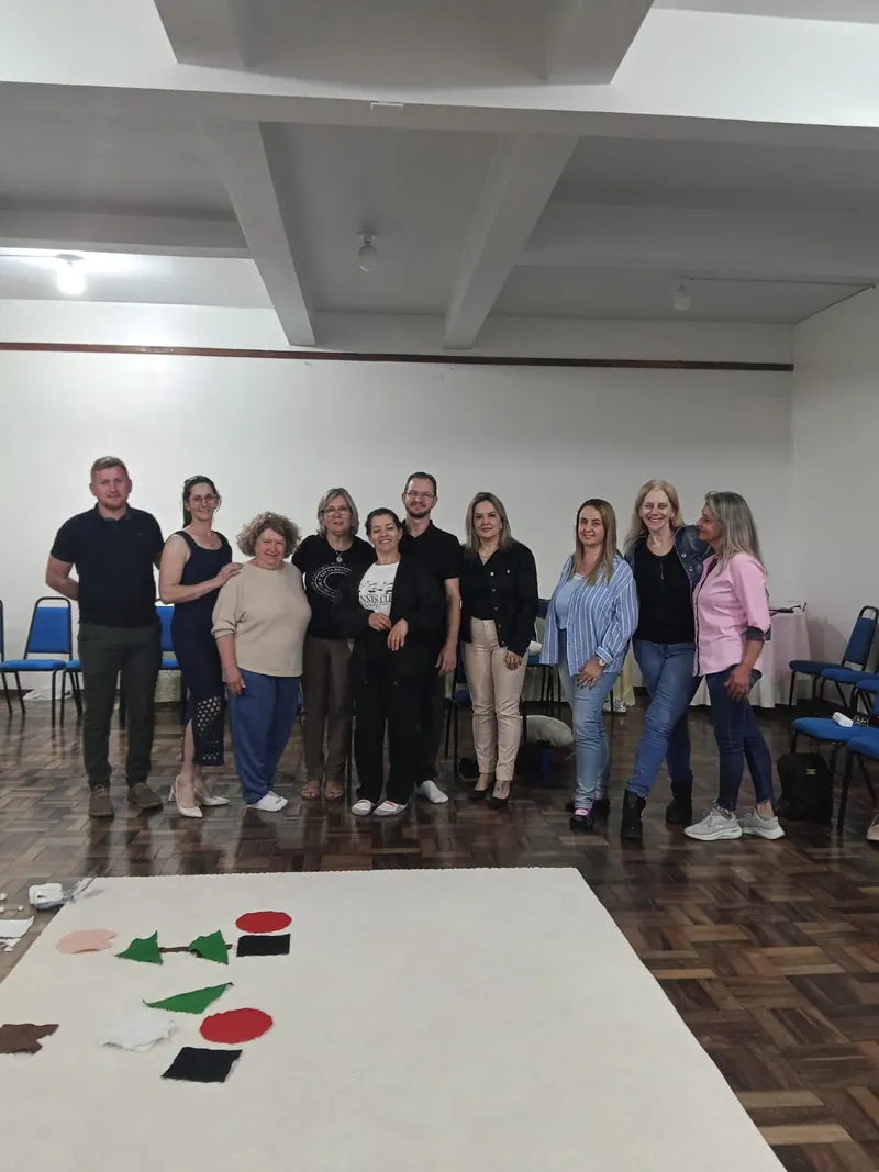 Turma de participantes e Edilson em pé, com o tapete branco da constelação à frente